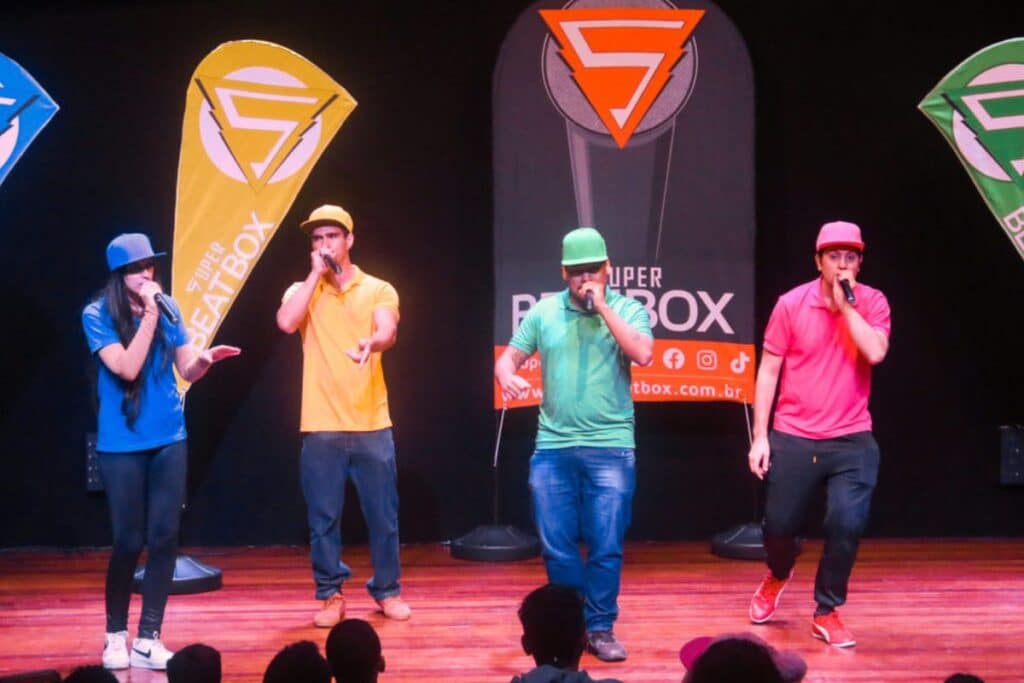 Apresentação de beatbox com quatro integrantes sobre palco de teatro
